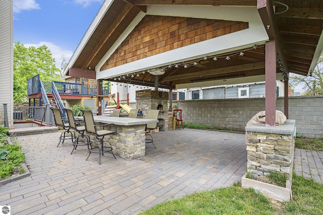 view of patio with outdoor dry bar, a gazebo, and stairs