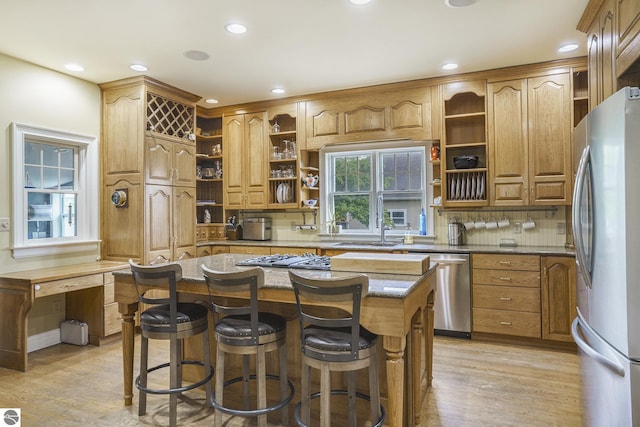 kitchen featuring backsplash, light stone countertops, light wood-style floors, stainless steel appliances, and open shelves