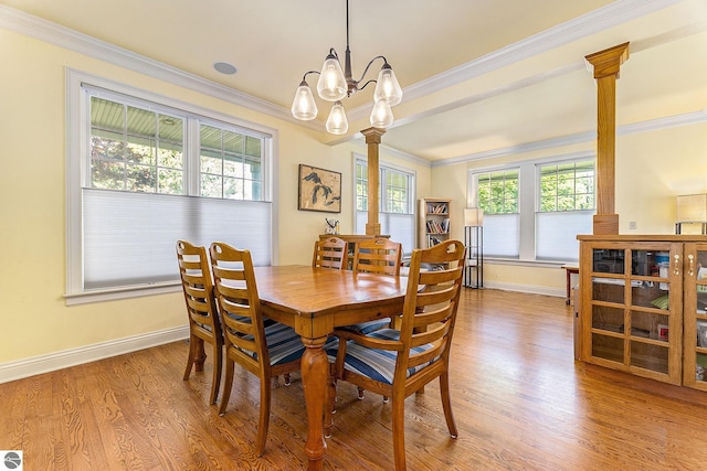 dining area with decorative columns, baseboards, wood finished floors, and crown molding