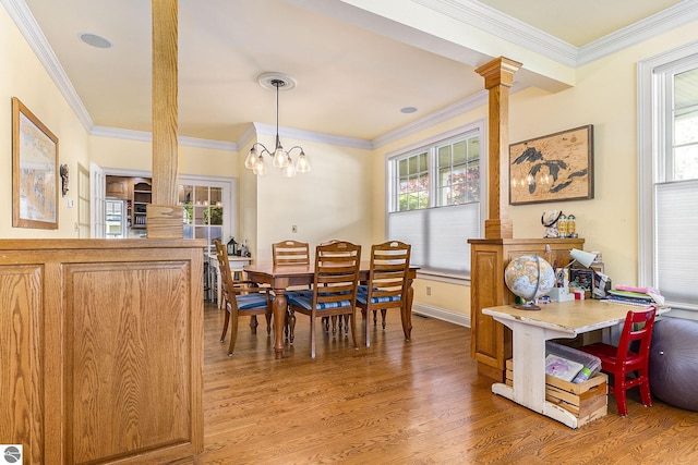 dining area with light wood-style floors, a wealth of natural light, and ornamental molding