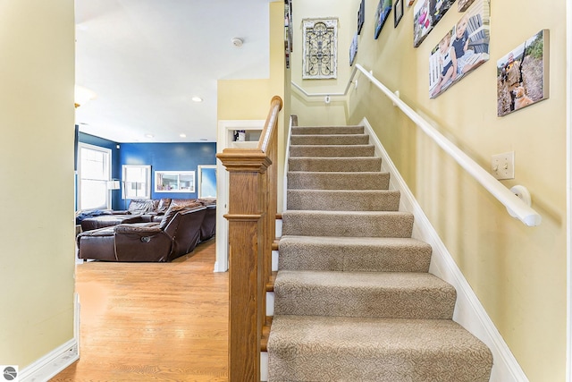 stairway featuring recessed lighting, wood finished floors, and baseboards