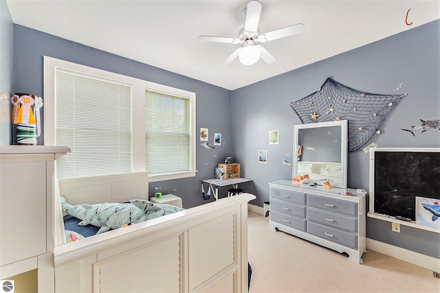 bedroom featuring light colored carpet, a ceiling fan, and baseboards