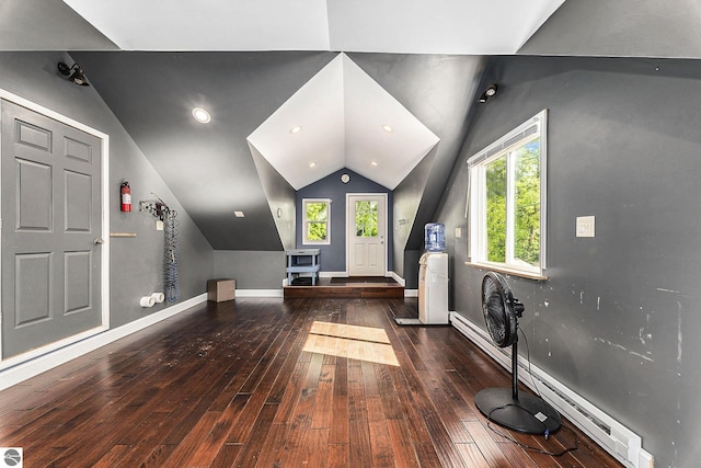 additional living space with a baseboard heating unit, hardwood / wood-style floors, recessed lighting, baseboards, and vaulted ceiling