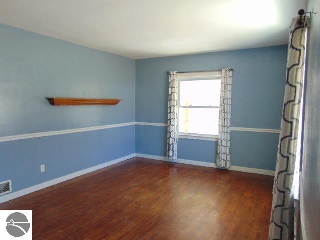 spare room with wood finished floors and baseboards