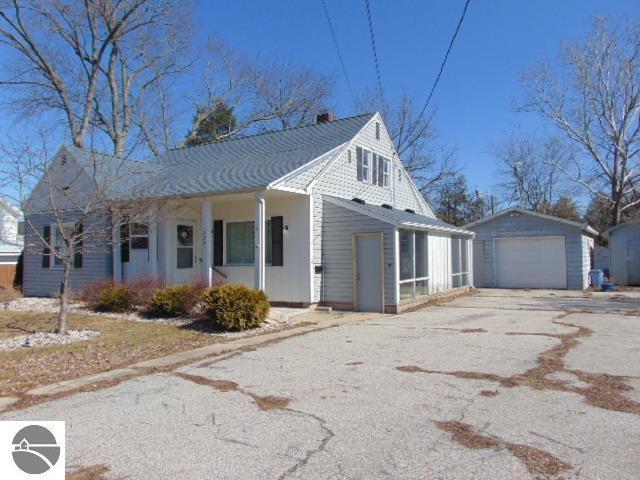 view of front of house featuring a garage, a porch, an outdoor structure, and driveway