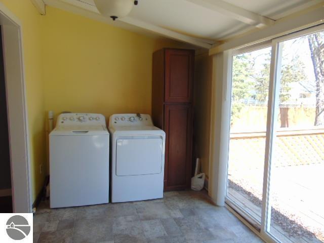 clothes washing area with independent washer and dryer and laundry area