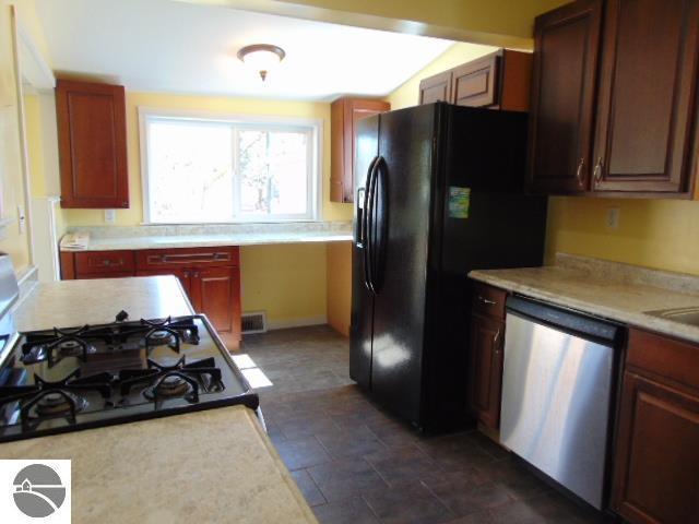 kitchen with dishwasher, light countertops, and visible vents