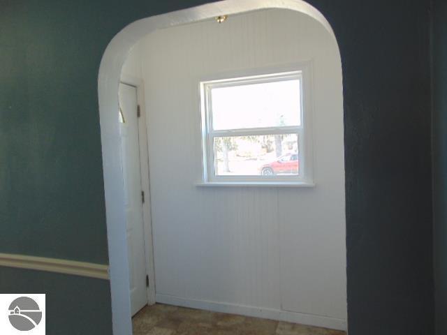 unfurnished room featuring arched walkways