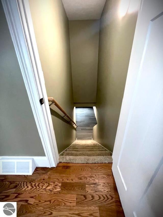 stairs featuring visible vents and wood finished floors