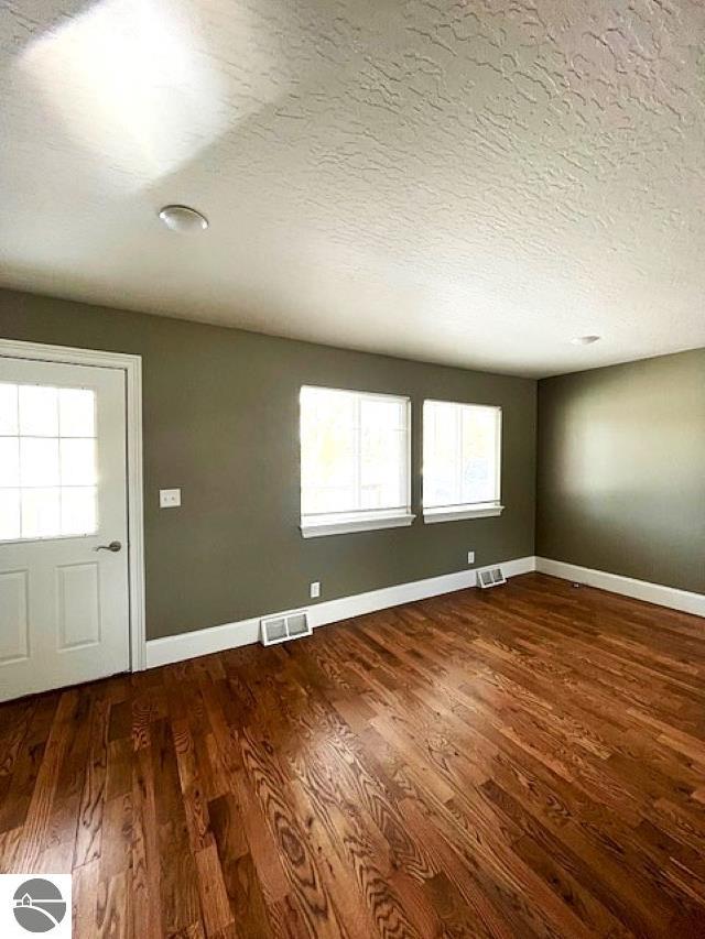 interior space featuring visible vents, baseboards, and wood finished floors