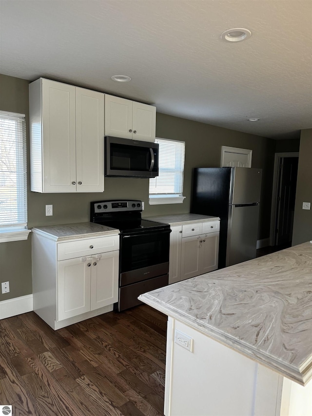 kitchen with a wealth of natural light, appliances with stainless steel finishes, and dark wood-style floors