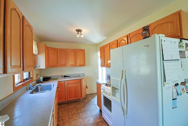 kitchen with a sink, white appliances, light tile patterned floors, and light countertops