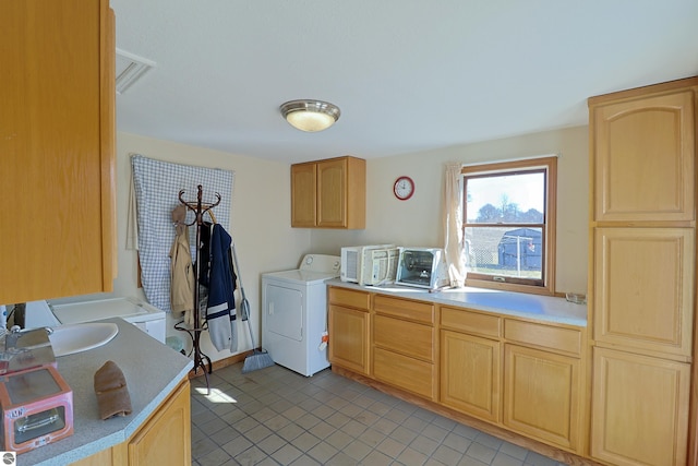 washroom with light tile patterned floors, a toaster, washer / clothes dryer, cabinet space, and a sink