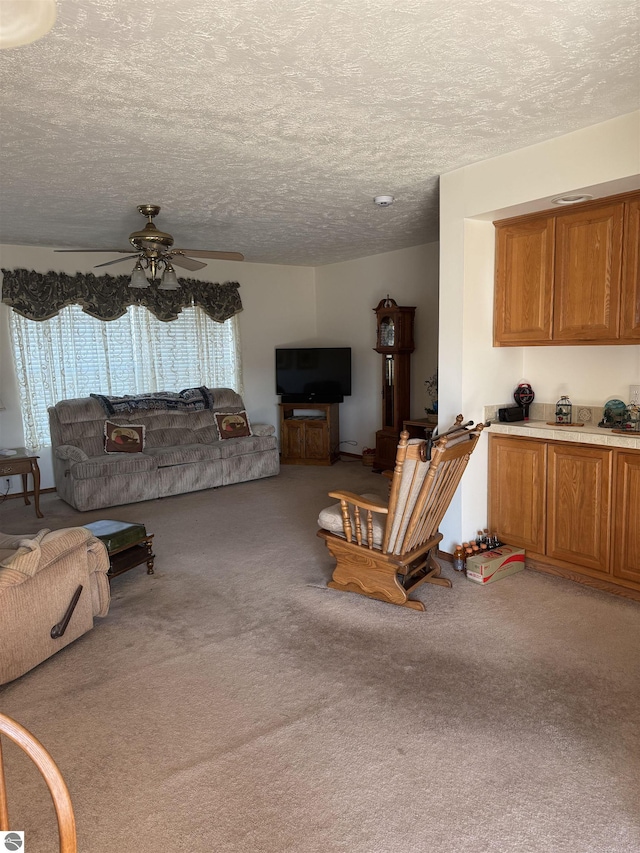 living area with carpet floors, a healthy amount of sunlight, and ceiling fan