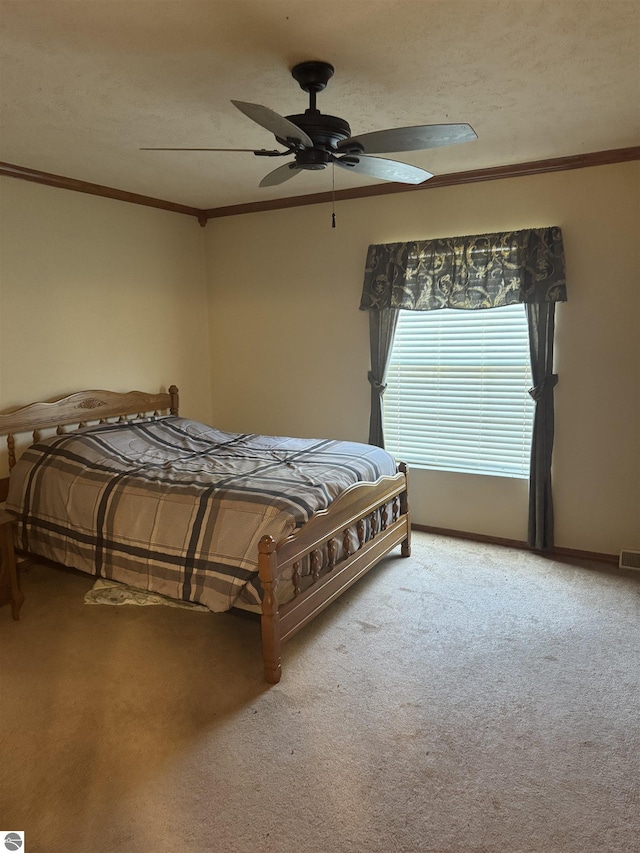 bedroom featuring carpet flooring, baseboards, ceiling fan, and crown molding