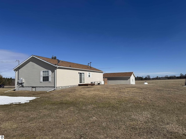 back of house with an outbuilding and a lawn