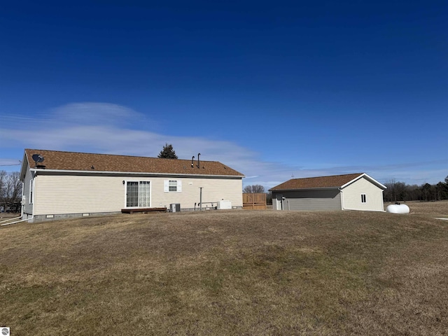 back of house with central air condition unit and a lawn