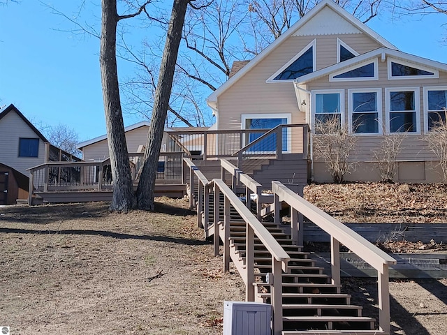 rear view of house with stairway and a wooden deck