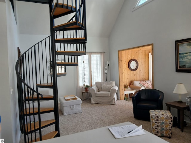 carpeted living room featuring high vaulted ceiling and stairs