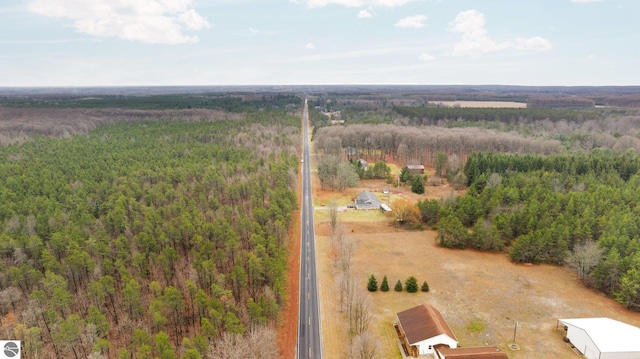 birds eye view of property featuring a rural view and a wooded view