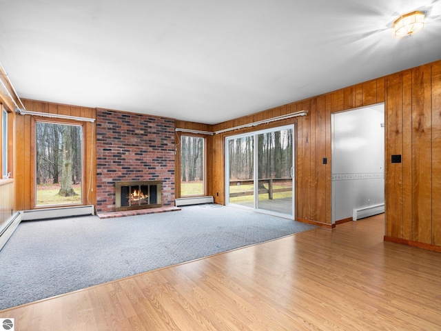 unfurnished living room with a fireplace, wood finished floors, and baseboard heating