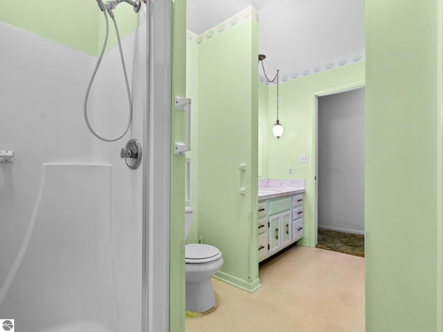 bathroom with a shower, baseboards, toilet, and vanity