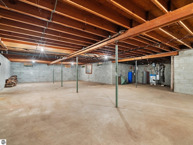 unfinished basement featuring gas water heater and a heating unit