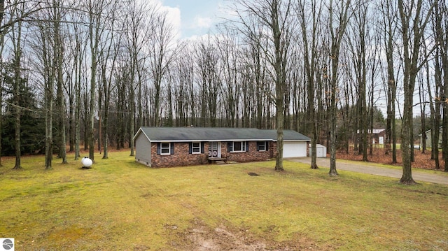 view of front of house with brick siding, a front lawn, aphalt driveway, crawl space, and an attached garage