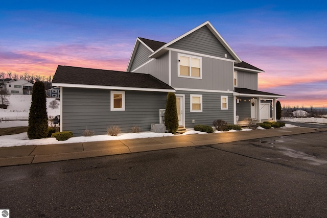 traditional home featuring driveway and a shingled roof