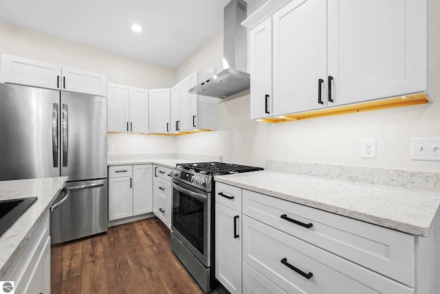 kitchen featuring light stone counters, stainless steel appliances, dark wood-type flooring, white cabinets, and wall chimney exhaust hood