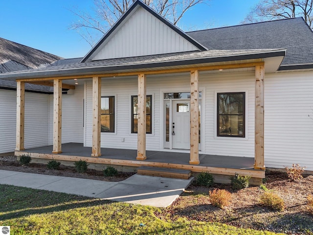 view of front of property with board and batten siding, covered porch, and a shingled roof