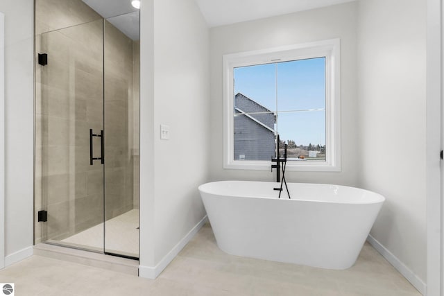 full bathroom featuring baseboards, a soaking tub, a stall shower, and tile patterned flooring