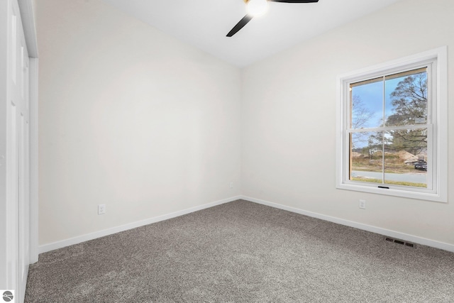 empty room featuring visible vents, carpet flooring, a ceiling fan, and baseboards