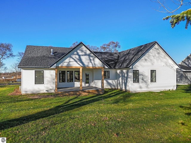 view of front of house with a front yard and a shingled roof