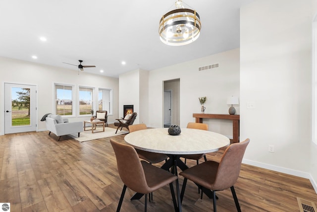 dining room with visible vents, baseboards, hardwood / wood-style floors, and a fireplace