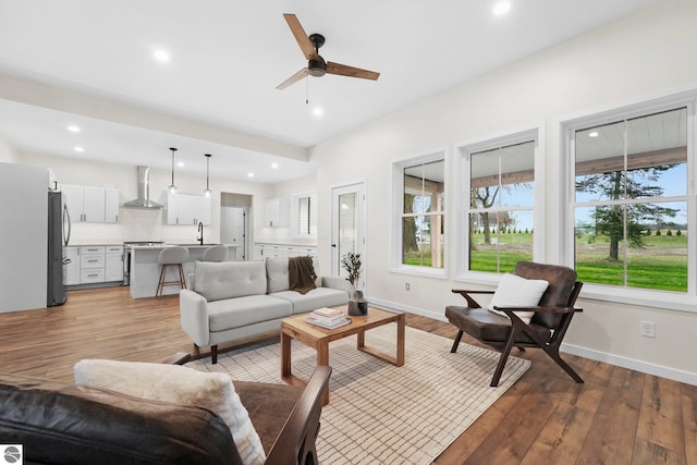 living area with recessed lighting, baseboards, light wood-style flooring, and a ceiling fan