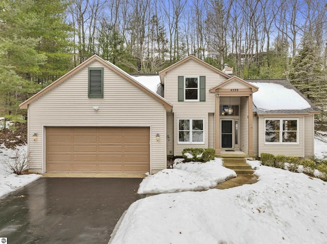 traditional-style home featuring aphalt driveway, a chimney, and an attached garage