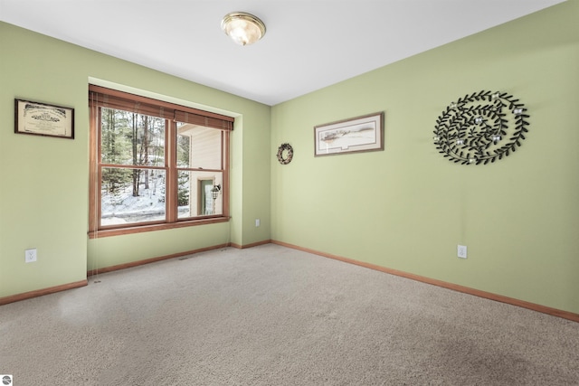 carpeted spare room with baseboards