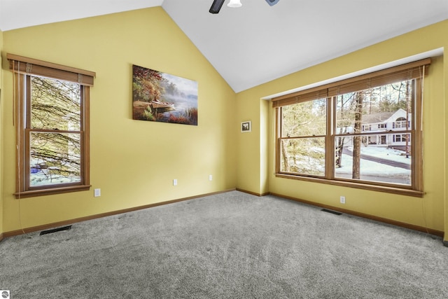 carpeted spare room featuring vaulted ceiling, plenty of natural light, baseboards, and visible vents