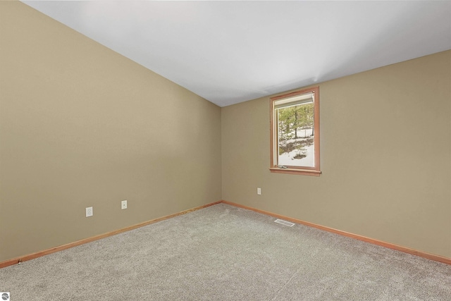 spare room with lofted ceiling, baseboards, and carpet floors