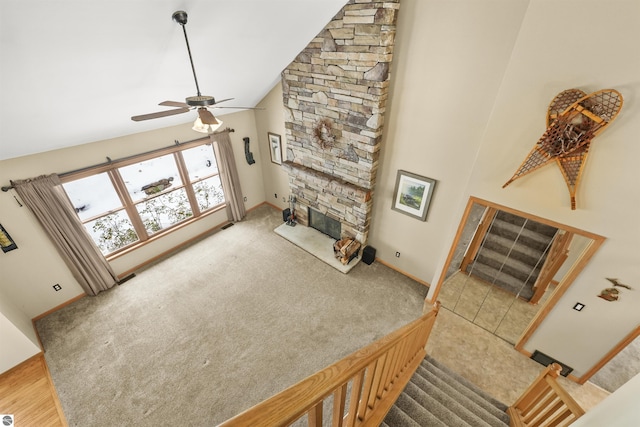 living room featuring carpet flooring, a fireplace, high vaulted ceiling, and ceiling fan