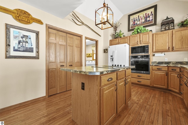 kitchen featuring stainless steel microwave, hardwood / wood-style floors, oven, and white fridge with ice dispenser