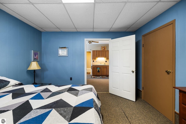 bedroom featuring a sink, a drop ceiling, and carpet floors