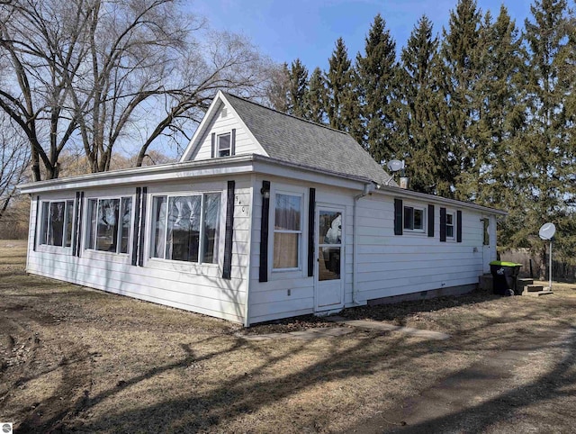 view of side of home with roof with shingles