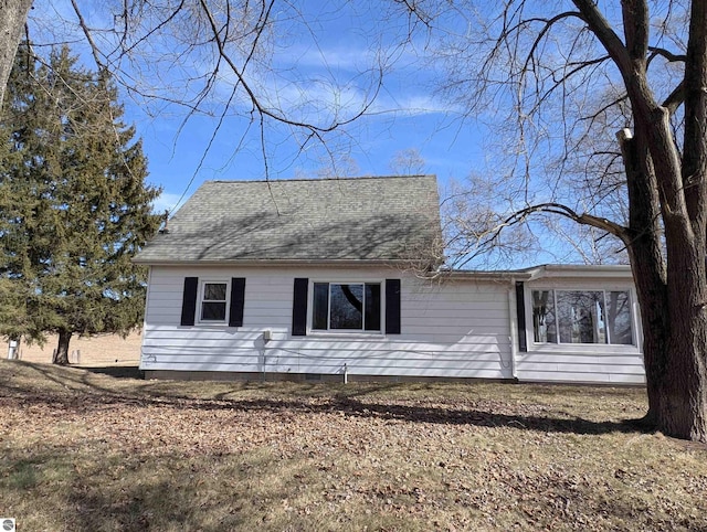 back of house with crawl space and a shingled roof