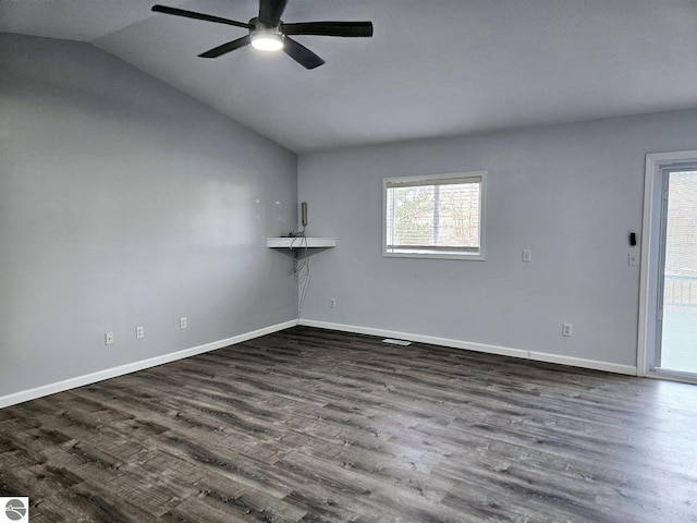 empty room with a ceiling fan, vaulted ceiling, baseboards, and dark wood-style flooring