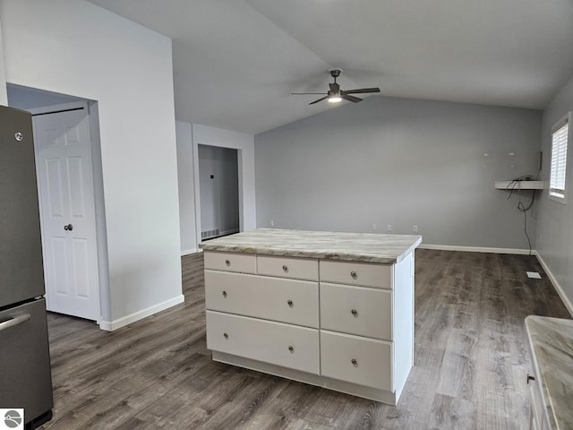 interior space with white cabinetry, vaulted ceiling, dark wood-style flooring, and freestanding refrigerator