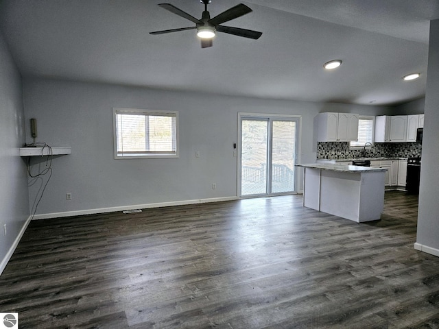 kitchen with white cabinetry, dark wood-type flooring, a healthy amount of sunlight, and open floor plan