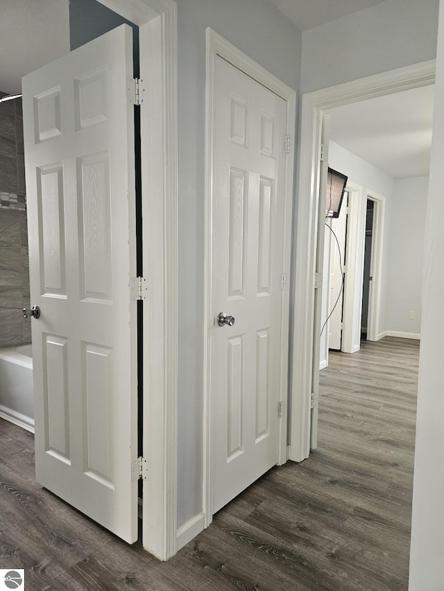 hallway featuring baseboards and dark wood-style flooring