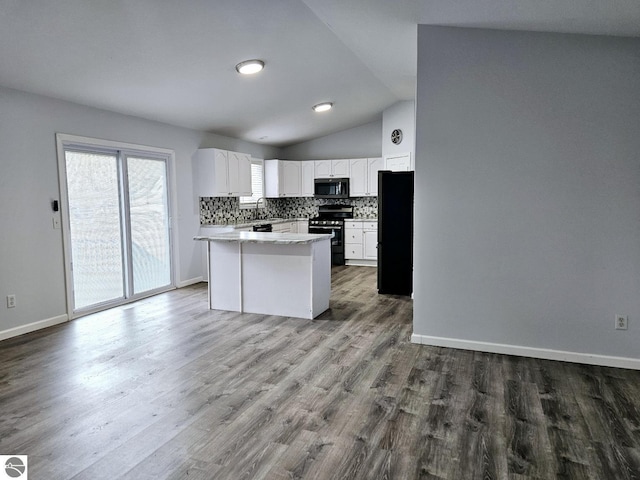 kitchen with stainless steel electric range, freestanding refrigerator, a sink, white cabinetry, and backsplash